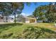 Lush backyard with healthy grass, trees, and view of the home's back exterior at 14220 Hendry Ct, Hudson, FL 34667