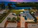 Waterfront property with beach access, manicured lawns, and a modern driveway at 1620 Sea Breeze Dr, Tarpon Springs, FL 34689