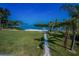 Waterfront backyard featuring a dock, lush greenery, and palm trees at 1620 Sea Breeze Dr, Tarpon Springs, FL 34689