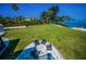 Relax in the backyard with lush lawn, an outdoor seating area, and mature trees at 1620 Sea Breeze Dr, Tarpon Springs, FL 34689