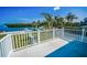 Balcony view of waterfront backyard with dock, lush greenery and tropical palm trees at 1620 Sea Breeze Dr, Tarpon Springs, FL 34689