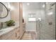 Modern bathroom with stone countertop, glass shower, and light wood cabinets at 1620 Sea Breeze Dr, Tarpon Springs, FL 34689