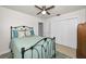 Bedroom featuring a black iron bed frame, ceiling fan, and white closet doors at 1620 Sea Breeze Dr, Tarpon Springs, FL 34689