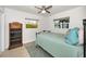 Inviting bedroom with vintage bookshelf, ceiling fan, and views of tropical landscape at 1620 Sea Breeze Dr, Tarpon Springs, FL 34689
