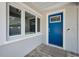 Charming entryway showcasing a blue front door, sidelight window and textured wall at 1620 Sea Breeze Dr, Tarpon Springs, FL 34689