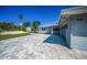 Beautiful gray home featuring a paver driveway, manicured lawn, and a partial view of the backyard at 1620 Sea Breeze Dr, Tarpon Springs, FL 34689