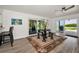 Bright living room featuring sliding glass doors, wood floors, and ceiling fan at 1620 Sea Breeze Dr, Tarpon Springs, FL 34689