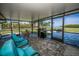 Screened patio with tile floor features comfortable seating, barbeque, and a stunning water view at 1620 Sea Breeze Dr, Tarpon Springs, FL 34689
