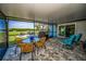 Screened patio features a table with chairs, barbeque, and a beautiful view of the water at 1620 Sea Breeze Dr, Tarpon Springs, FL 34689