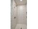 Stylish shower with patterned tile walls, pebble floor, and modern fixtures at 1620 Sea Breeze Dr, Tarpon Springs, FL 34689