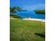 This waterfront property features a grassy lawn with adirondack chairs and stunning water views at 1620 Sea Breeze Dr, Tarpon Springs, FL 34689