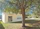Exterior view of home features sliding glass door and yard with a mature tree at 19551 Timberbluff Dr, Land O Lakes, FL 34638