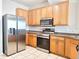 Kitchen featuring stainless steel appliances, wood cabinets, and granite countertops at 19551 Timberbluff Dr, Land O Lakes, FL 34638