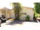 Home exterior view showing the carport, yard, and mature landscaping and plants at 20960 Little Magens Loop, Lutz, FL 33558