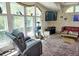 Bright living room boasts vaulted ceilings, a TV, oversized windows with green views, and a recliner, offering comfort at 20960 Little Magens Loop, Lutz, FL 33558