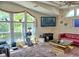 Bright living room with vaulted ceilings, ample windows, a red couch, TV, and carpeted floors, providing a cozy ambiance at 20960 Little Magens Loop, Lutz, FL 33558