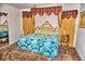 Spacious bedroom with turquoise bedspread, decorative headboard and curtains at 20960 Little Magens Loop, Lutz, FL 33558