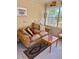 Sunroom with an inviting, cushioned couch, side table and a view of greenery at 20960 Little Magens Loop, Lutz, FL 33558
