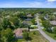 Aerial view of the homes in the neighborhood surrounded by lush green trees at 2443 Glenridge Dr, Spring Hill, FL 34609
