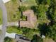 Birds eye view of a home with a brown roof surrounded by mature trees in a neighborhood setting at 2443 Glenridge Dr, Spring Hill, FL 34609