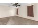 Spacious bedroom with neutral walls, carpet flooring, a ceiling fan, and two curtained windows at 2443 Glenridge Dr, Spring Hill, FL 34609