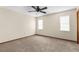 A spacious bedroom with neutral carpet, fan, and ample natural light from two windows at 2443 Glenridge Dr, Spring Hill, FL 34609