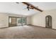Bright living room with sliding glass doors to the patio, neutral walls, and carpeted flooring at 2443 Glenridge Dr, Spring Hill, FL 34609
