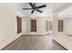 Living room features neutral carpet, fan and window, with tile leading to sunroom at 2443 Glenridge Dr, Spring Hill, FL 34609