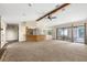 Expansive living room showcasing open layout, stone fireplace, breakfast bar, and access to the enclosed patio at 2443 Glenridge Dr, Spring Hill, FL 34609
