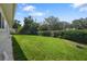 Lush backyard featuring a well-maintained lawn and mature landscaping for privacy and beauty at 2866 Thistle N Ct, Palm Harbor, FL 34684