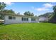 Spacious backyard with a well-manicured lawn surrounding the home at 2866 Thistle N Ct, Palm Harbor, FL 34684