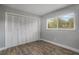 Bedroom with laminate wood flooring, a bright window and closet with folding doors at 2866 Thistle N Ct, Palm Harbor, FL 34684