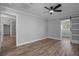 Spacious bedroom with fan, wood-look floors, and a modern barn door to an adjacent room at 2866 Thistle N Ct, Palm Harbor, FL 34684