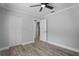 Spacious bedroom features neutral walls, luxury vinyl plank flooring, modern ceiling fan, and bright window at 2866 Thistle N Ct, Palm Harbor, FL 34684