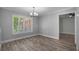 Bright dining room featuring wood floors, large window with white shutters, and contemporary chandelier at 2866 Thistle N Ct, Palm Harbor, FL 34684