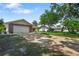 View of the home from the street, showcasing a large driveway and mature trees surrounding the property at 2866 Thistle N Ct, Palm Harbor, FL 34684