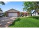 Charming single-story home featuring a brick facade, manicured lawn, and spacious two-car garage at 2866 Thistle N Ct, Palm Harbor, FL 34684