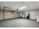 Spacious garage with plenty of room for storage, a modern garage door, and side door access at 2866 Thistle N Ct, Palm Harbor, FL 34684