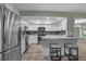 Well-lit eat-in kitchen features stainless steel appliances, white cabinets, and granite countertops at 2866 Thistle N Ct, Palm Harbor, FL 34684