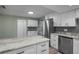Kitchen with granite countertops, stainless steel appliances, white cabinets, and a sliding barn door at 2866 Thistle N Ct, Palm Harbor, FL 34684