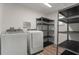 Bright laundry room features washer, dryer, shelving and a small window at 2866 Thistle N Ct, Palm Harbor, FL 34684