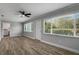 Open living room with wood floors, large windows, and ceiling fan; utility room visible at 2866 Thistle N Ct, Palm Harbor, FL 34684