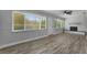 Well-lit living room featuring a stone fireplace, modern floors, and ample natural light through large windows at 2866 Thistle N Ct, Palm Harbor, FL 34684