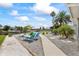 Waterfront backyard featuring lounge chairs and gravel landscaping with palm trees at 3907 Headsail Dr, New Port Richey, FL 34652