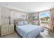 Bright bedroom with wood-look tile flooring, mounted television, and large window at 3907 Headsail Dr, New Port Richey, FL 34652