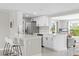 Bright kitchen features white cabinets, stainless appliances, bar seating, and an open view to the living area at 3907 Headsail Dr, New Port Richey, FL 34652