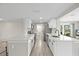 A modern kitchen features white cabinets, stainless appliances, and a view to the screened-in porch at 3907 Headsail Dr, New Port Richey, FL 34652