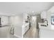 Bright kitchen boasts white cabinetry, stainless appliances, an island with bar seating, and stylish tile flooring at 3907 Headsail Dr, New Port Richey, FL 34652