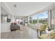 Bright living room featuring large windows, gray sofa, coastal rug, and an open floor plan to the kitchen at 3907 Headsail Dr, New Port Richey, FL 34652