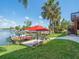 Waterfront backyard with dock, patio set, and lush landscaping at 4292 Tahiti Dr, Hernando Beach, FL 34607